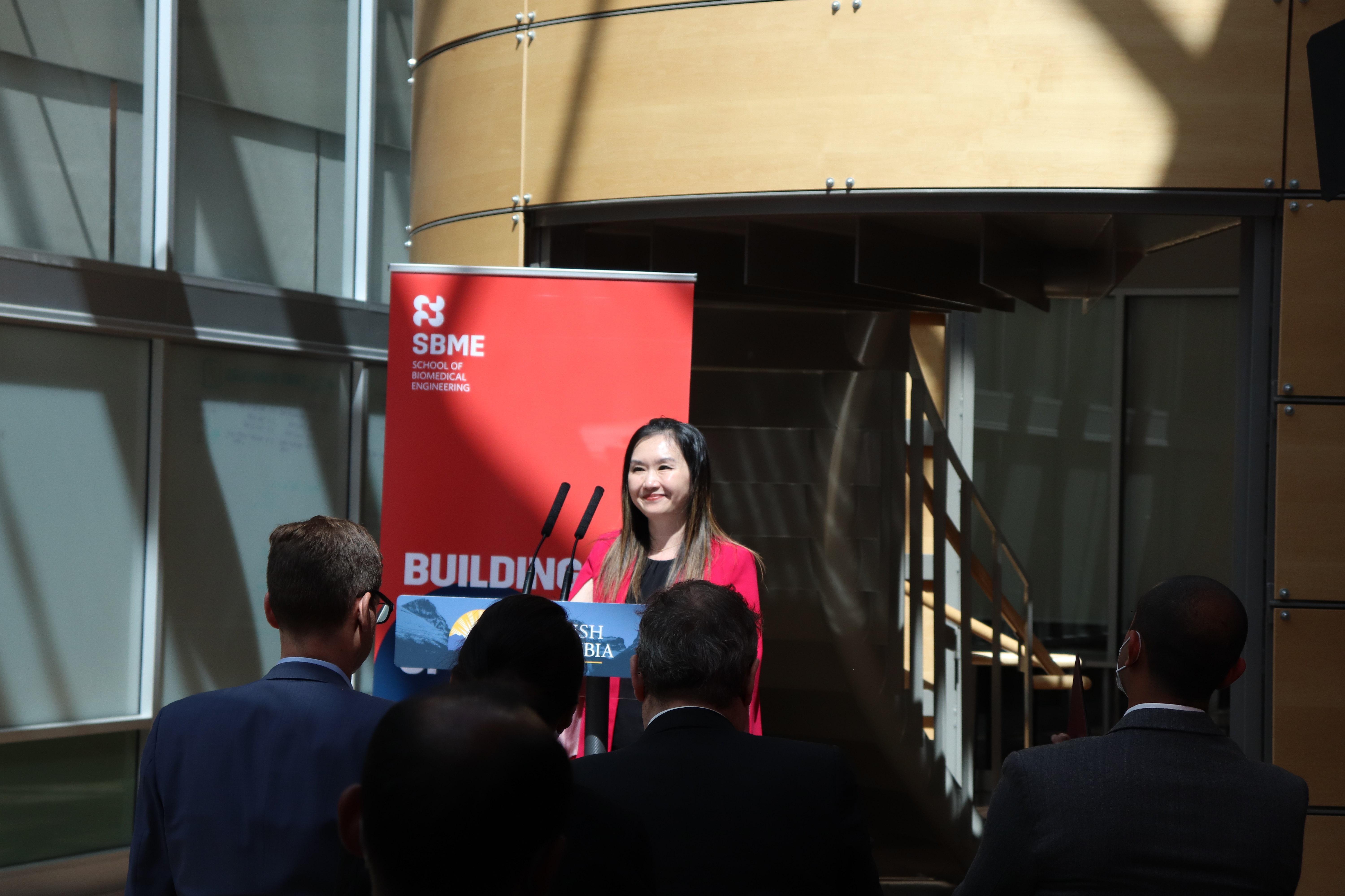 Minister Anne Kang standing at the podium