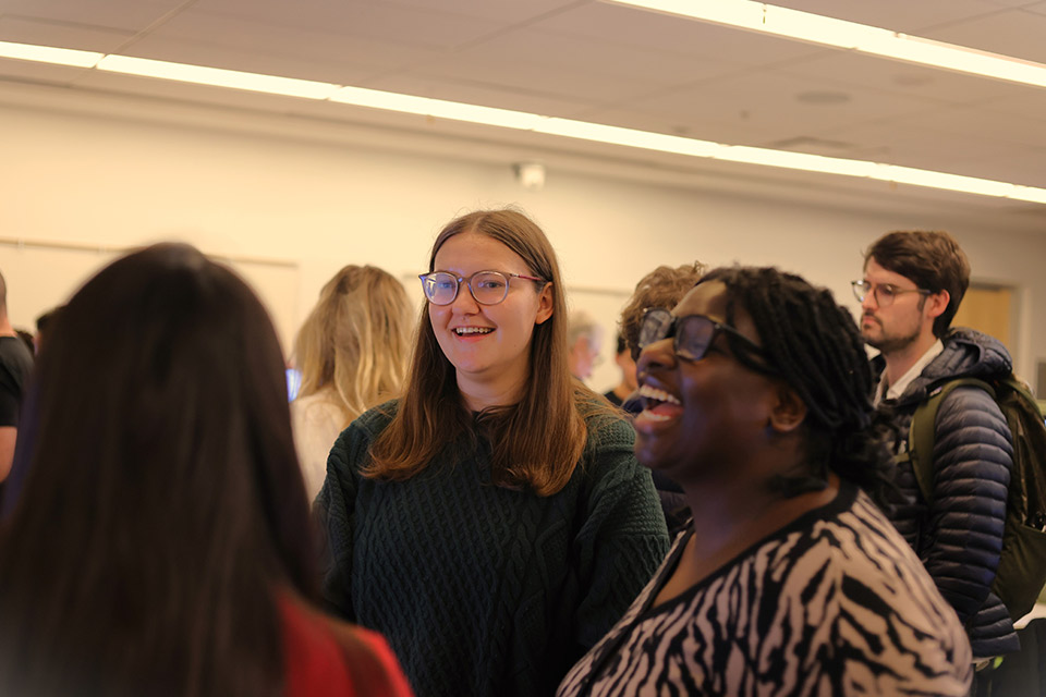 Group of students talking and laughing at an event