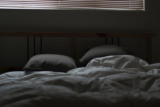 Empty bed in dark room