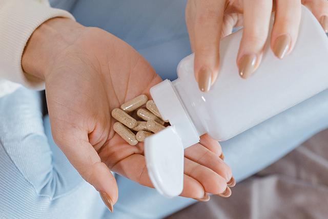 A person holding tablets in their hand.