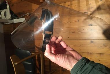 Alumnus Dylan Gunn holding a face shield prototype he created