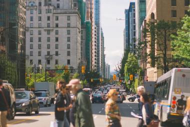 People crossing Georgia St in downtown Vancouver.