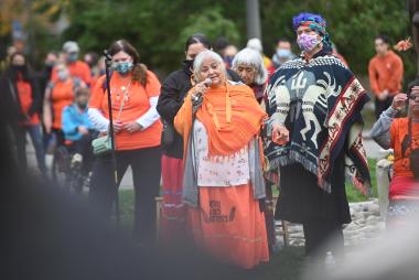 Elder Pauline Johnson and a crowd of orange shirts gathers near Reconcilation Pole on National Day for Truth and Reconciliation