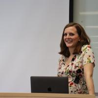 Woman in flowery dress at lectern